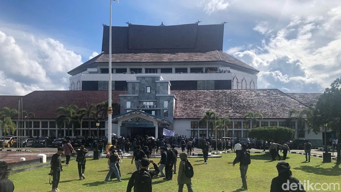 Massa aksi berlarian menuju pintu gedung DPRD Kota Palangkaraya.