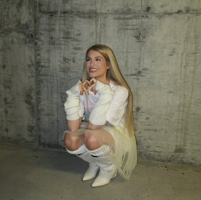 Dalam unggahan Instagram terbaru, penyanyi 31 tahun ini terlihat mengenakan kaus putih yang dipadukan dengan gaun sifon transparan. Gayanya semakin unik dengan tambahan leg dan arm warmer putih, serta boots kulit model shark. Foto: Instagram/@meghantrainor