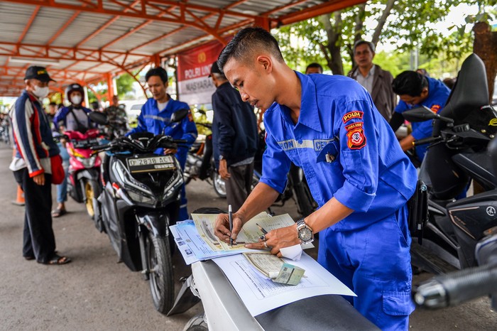 Petugas memeriksa nomor kendaraan milik seorang warga di Samsat Kawaluyaan, Bandung, Jawa Barat, Senin (24/3/2025). Pemerintah Provinsi Jawa Barat mengadakan program pemutihan pajak kendaraan bermotor yang berlaku mulai 20 Maret hingga 6 Juni 2025, pada program pemutihan tersebut masyarakat Jawa Barat mendapatkan pembebasan tunggakan pokok pajak kendaraan serta denda pajak yang terakumulasi dari tahun-tahun sebelumnya. ANTARA FOTO/Raisan Al Farisi/Spt.