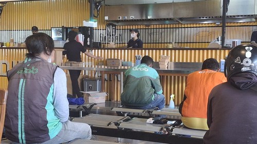 Beberapa pengemudi ojek online sedang menunggu pesanan mereka selesai di salah satu tempat makan di Canggu, Badung, Bali, Selasa (25/3/2025).