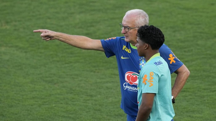 Brazils coach Dorival Junior, back, talks with player Endrick before a national soccer team training session, in Brasilia, Brazil, Monday, March 17, 2025. (AP Photo/Eraldo Peres)