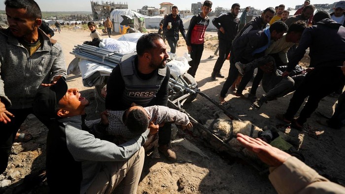 Palestinians react at the site of an Israeli strike, which according to medics, killed journalist Hossam Shabat, in the northern Gaza Strip March 24, 2025. REUTERS/Mahmoud Issa