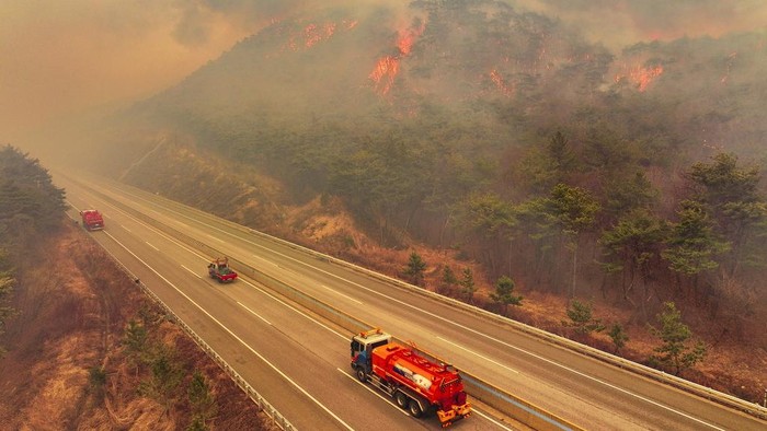 A Korea Forest Service helicopter dumps fire retardant on a wildfire in Uiseong, South Korea, Monday, March 24, 2025. (Yoon Gwan-shick/Yonhap via AP)