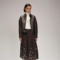 Prada menghadirkan estetika minimal-maksimal dalam koleksi Ramadan dengan sentuhan elegan dan cermat. Koleksi wanita menampilkan rok lipit klasik dalam nuansa abu-abu, burgundy, dan beige, diperkaya payet serta kilau mewah, sementara gaun dan rok sutra panjang dengan hiasan kristal dan cermin menawarkan kesan dramatis. (Foto: Dok. Prada)