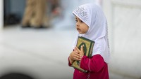 Seorang anak perempuan memeluk Al-Quran. Foto: Kementerian Haji dan Umrah Arab Saudi