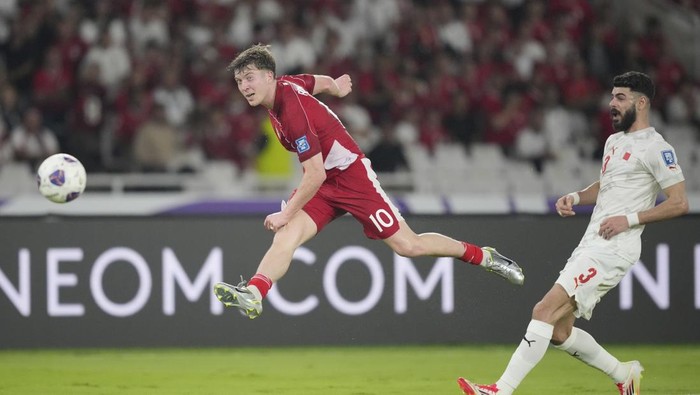 Indonesias Ole Lennard Romenij, left, shoots past Bahrains Waleed Alhayam during a World Cup 2026 group C Asia qualifying soccer match between Indonesia and Bahrain at Gelora Bung Karno Main Stadium in Jakarta, Indonesia, Tuesday, March 25, 2025. (AP Photo/Tatan Syuflana)