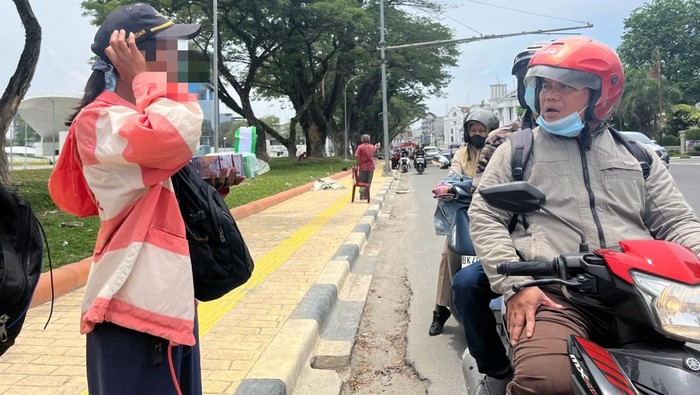 Penjual uang baru di Medan menjajakan dagangannya ke warga yang melintas. (Kartika Sari/detikSumut)