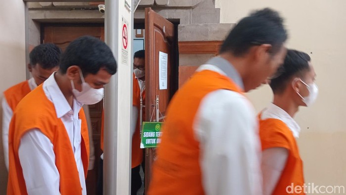 Sebanyak 12 terdakwa kasus pencurian data dan penjualan kartu SIM ilegal digiring kembali ke tahanan seusai menjalani sidang di PN Denpasar, Selasa (25/3/2025). (Foto: Aryo Mahendro/detikBali)