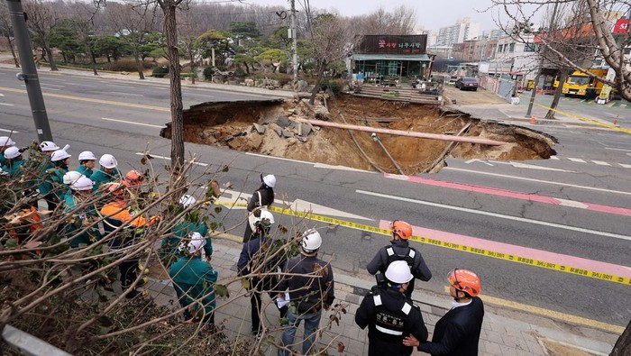 Sinkhole Raksasa Muncul di Jalanan Korsel, 1 Orang Tewas Emergency workers stand near a sinkhole in a road, in Seoul, South Korea, March 25, 2025. Yonhap via REUTERS THIS IMAGE HAS BEEN SUPPLIED BY A THIRD PARTY. NO RESALES. NO ARCHIVES. SOUTH KOREA OUT. NO COMMERCIAL OR EDITORIAL SALES IN SOUTH KOREA TPX IMAGES OF THE DAY
