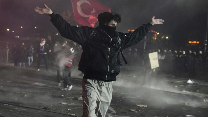Anti riot police officers run after people in Istanbul, Turkey, Monday, March 24, 2025, during a protest after Istanbul's Mayor Ekrem Imamoglu was arrested and sent to prison. (AP Photo/Khalil Hamra)