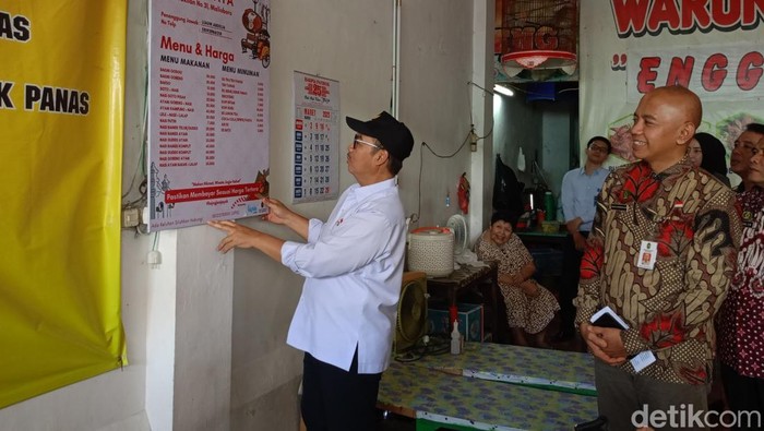 Walkot Jogja Hasto Wardoyo saat memasang daftar menu di salah satu warung di kawasan Malioboro, Selasa (25/3/2025).