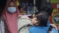 Seorang anak yang ikut mudik tampak kelelahan.   