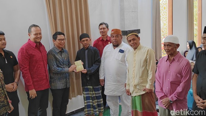 Bupati I Wayan Adi Arnawa menyerahkan bantuan kepada para kepala keluarga penerima bansos asal Dusun Angantiga, Petang, Rabu (26/3/2025).