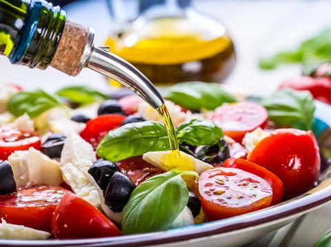 Caprese. Caprese salad. Italian salad. Mediterranean salad. Italian cuisine. Mediterranean cuisine. Tomato mozzarella basil leaves black olives and olive oil on wooden table. Recipe - Ingredients