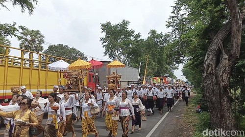 Iring-iringan melasti berbagi jalan dengan antrean kendaraan pemudik di Jalan Denpasar-Gilimanuk, Jembrana, Bali, Rabu (26/3/2025). (Foto: I Putu Adi Budiastrawan/detikBali)