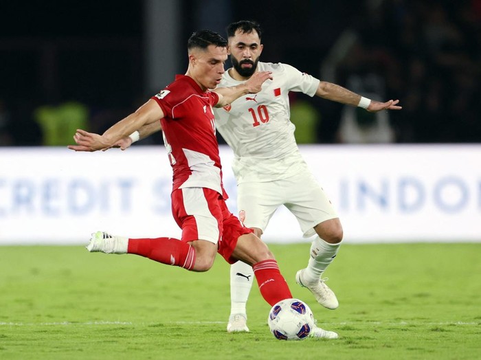 Soccer Football - World Cup - AFC Qualifiers - Third Round - Group C - Indonesia v Bahrain - Gelora Bung Karno Complex, Jakarta, Indonesia - March 25, 2025 Bahrains Komail Al Aswad in action with Indonesias Joey Pelupessy REUTERS/Ajeng Dinar Ulfiana