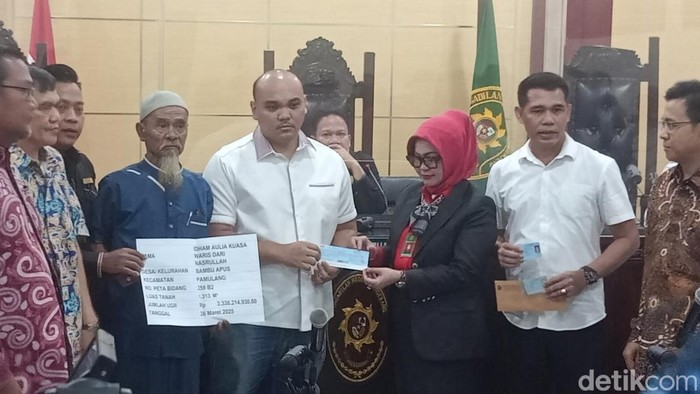 Keluarga Mat Solar diwakili anak tertua Idham Aulia dan H Idris menerima cek Rp 3,3 miliar.