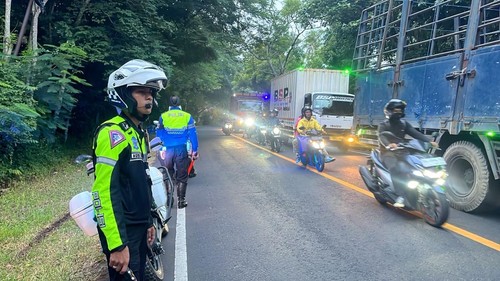 Polisi jaga di pinggir jalan agar tidak ada kendaraan yang mendahului antrian dari lajur kanan, Rabu (26/3/2025). (Dok Polda Bali).