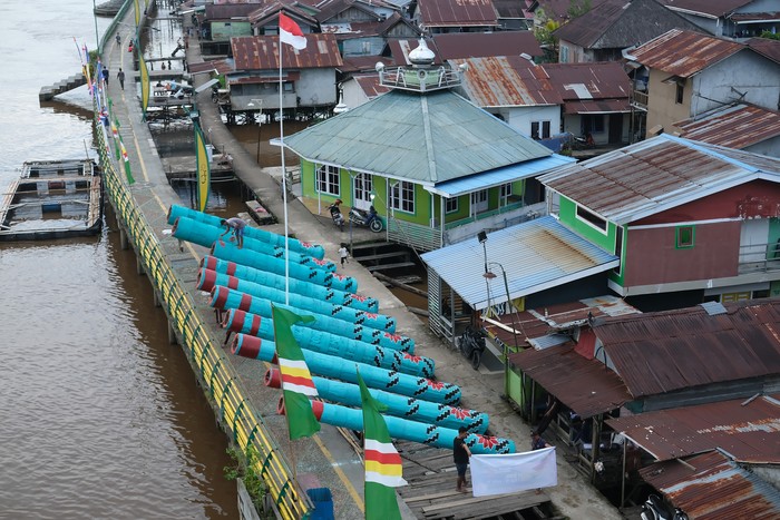 Warga menempatkan meriam karbit yang terbuat dari kayu gelondongan di badan jembatan di tepian Sungai Kapuas di Kelurahan Tambelan Sampit, Pontianak, Kalimantan Barat, Rabu (26/3/2025). Meriam karbit sepanjang tujuh hingga delapan meter dengan diameter 90 centimeter yang dililit rotan tersebut dipersiapkan oleh masyarakat setempat untuk memeriahkan malam takbiran dan Idul Fitri 1446 H di tepian Sungai Kapuas. ANTARA FOTO/Jessica Wuysang/nym.