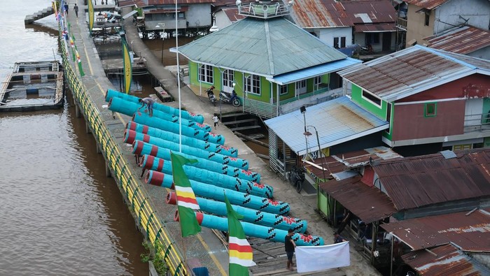 Warga menempatkan meriam karbit yang terbuat dari kayu gelondongan di badan jembatan di tepian Sungai Kapuas di Kelurahan Tambelan Sampit, Pontianak, Kalimantan Barat, Rabu (26/3/2025). Meriam karbit sepanjang tujuh hingga delapan meter dengan diameter 90 centimeter yang dililit rotan tersebut dipersiapkan oleh masyarakat setempat untuk memeriahkan malam takbiran dan Idul Fitri 1446 H di tepian Sungai Kapuas. ANTARA FOTO/Jessica Wuysang/nym.