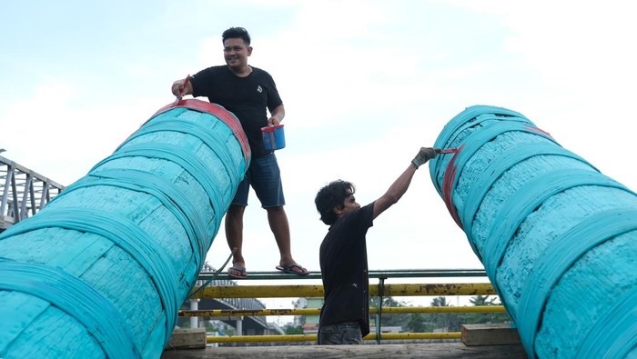 Warga menempatkan meriam karbit yang terbuat dari kayu gelondongan di badan jembatan di tepian Sungai Kapuas di Kelurahan Tambelan Sampit, Pontianak, Kalimantan Barat, Rabu (26/3/2025). Meriam karbit sepanjang tujuh hingga delapan meter dengan diameter 90 centimeter yang dililit rotan tersebut dipersiapkan oleh masyarakat setempat untuk memeriahkan malam takbiran dan Idul Fitri 1446 H di tepian Sungai Kapuas. ANTARA FOTO/Jessica Wuysang/nym.