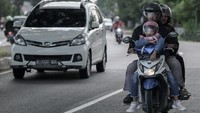 Pemudik sepeda motor membawa anaknya melintas ke arah Cirebon dan Jawa Tengah di Jalan Raya Pantura, Indramayu, Jawa Barat, Rabu (26/3/2025).