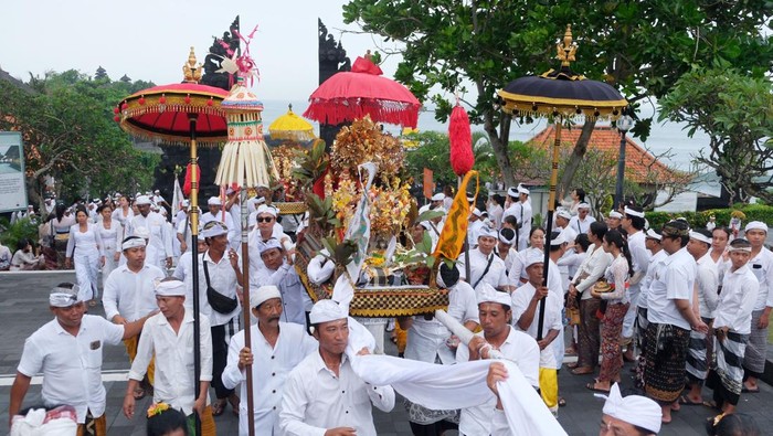 Umat Hindu membawa benda sakral saat upacara Melasti di Tanah Lot, Tabanan, Bali, Rabu (26/3/2025). Upacara yang serentak dilaksanakan umat Hindu se-Bali tersebut untuk menyucikan diri dari segala perbuatan buruk, membersihkan alam dari energi negatif, dan memohon kepada Tuhan untuk diberikan keselamatan serta kesejahteraan dalam menyambut Hari Raya Nyepi Tahun Baru Saka 1947 pada Sabtu (29/3/2025). ANTARA FOTO/Nyoman Hendra Wibowo
