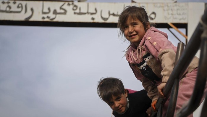 Local residents wait on the side of the road to be evacuated due to fears of Israeli army incursions, following a drone attack that reportedly killed at least four people in the area, on the outskirts of the village of Koayiah, southwestern Syria, Tuesday, March 25, 2025. (AP Photo/Omar Albam)
