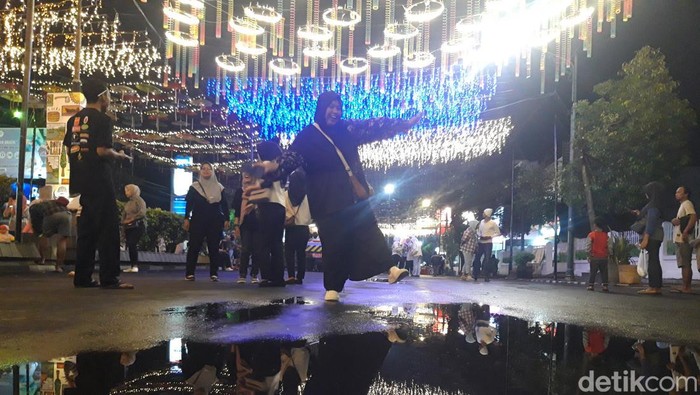Warga berfoto di bawah lampu-lampu hias Boyolali City Light, Kamis (27/3/2025) malam.