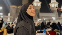 Ibu satu anak itu tersenyum semringah foto dengan latar Zam Zam Tower saat iktikaf di Masjidil Haram. Foto: dok. Instagram Citra Kirana