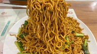 Mie goreng disajikan dengan irisan daging ayam dan sayur sawi dan telur. KArena dimasak dengan wok dan api besar, tekstur mie jadi garing. Foto: detikFood