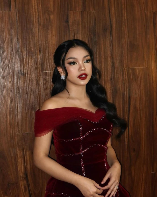 Rambut panjangnya ditata bergelombang dan dikuncir tengah, mempermanis fitur wajahnya yang ayu. Foto: Instagram/@naura.ayu