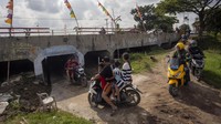 Pengendara motor menyeberang jalur pantura melalui kolong jembatan di Desa Legok, Indramayu, Jawa Barat, Kamis (27/3/2025).