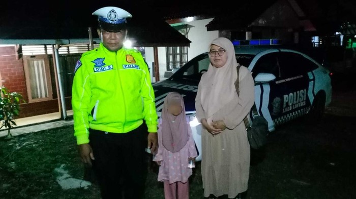 Polisi bantu antar ibu dan anak yang ketiduran hingga diturunkan bus rombongan mudik gratis di Tol Cipali. (dok.istimewa)