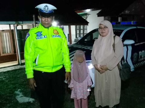 Polisi bantu antar ibu dan anak yang ketiduran hingga diturunkan bus rombongan mudik gratis di Tol Cipali. (dok.istimewa)