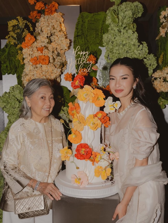 Jika sebelumnya pesta ulang tahun Raline bertema bohemian, kali ini dekorasi ulang tahunnya itu tampak cantik dipenuhi dengan bunga-bunga berwarna cerah. Senada dengan dekorasinya, kue ulang tahun Raline juga terlihat simpel namun tetap elegan dengan bentuk bunga-bunga berwarna oranye. Foto: Instagram/@ralineshah