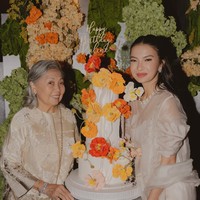 Jika sebelumnya pesta ulang tahun Raline bertema bohemian, kali ini dekorasi ulang tahunnya itu tampak cantik dipenuhi dengan bunga-bunga berwarna cerah. Senada dengan dekorasinya, kue ulang tahun Raline juga terlihat simpel namun tetap elegan dengan bentuk bunga-bunga berwarna oranye. Foto: Instagram/@ralineshah