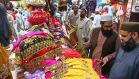 Mereka datang untuk berbelanja kebutuhan Idul Fitri. AP/Muhammad Sajjad