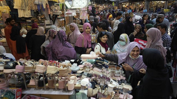 Warga Pakistan Padati Pasar Berburu Kebutuhan Lebaran Women look at footwear as they visit a market to shop for the upcoming Eid al-Fitr celebrations, which marks the end of the Islamic holy month of Ramadan, in Lahore, Pakistan, Monday, March 24, 2025. (AP Photo/K.M. Chaudary)