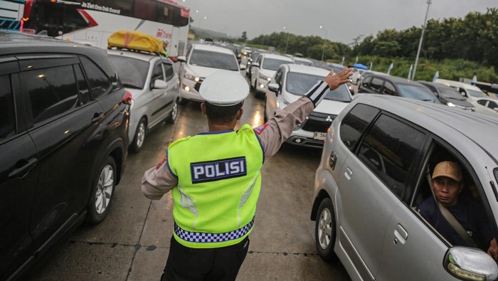 Anggota kepolisian mengatur arus lalu lintas kendaraan pemudik di Gerbang Tol (GT) Kalikangkung Semarang-Batang, Semarang, Jawa Tengah, Jumat (28/3/2025). Berdasarkan data PT Jasa Marga Semarang Batang pada puncak arus mudik H-3 Lebaran tercatat sebanyak 51.168 unit kendaraan melintas di Gerbang Tol Kalikangkung atau mengalami lonjakan signifikan dibandingkan H-5 Lebaran yang hanya 39.154 unit kendaraan dan pemberlakuan skema satu arah nasional mulai diterapkan hingga ruas Tol Semarang-Batang KM 414. ANTARA FOTO/Makna Zaezar/agr