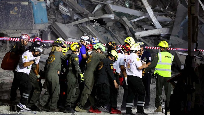 A rescue personnel searches for casualties at the site of a building that collapsed after a strong earthquake struck central Myanmar on Friday, earthquake monitoring services said, which affected Bangkok as well with people pouring out of buildings in the Thai capital in panic after the tremors, in Bangkok, Thailand, March 28, 2025. REUTERS/Athit Perawongmetha