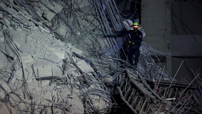 Gedung di Bangkok Ambruk Imbas Gempa Myanmar A rescue personnel searches for casualties at the site of a building that collapsed after a strong earthquake struck central Myanmar on Friday, earthquake monitoring services said, which affected Bangkok as well with people pouring out of buildings in the Thai capital in panic after the tremors, in Bangkok, Thailand, March 28, 2025. REUTERS/Athit Perawongmetha