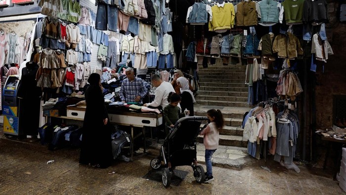 A worker carries traditional sweets as Palestinians prepare for the upcoming holiday of Eid al-Fitr marking the end of Ramadan, in Jerusalem Old City, March 27, 2025.REUTERS/Ammar Awad     TPX IMAGES OF THE DAY