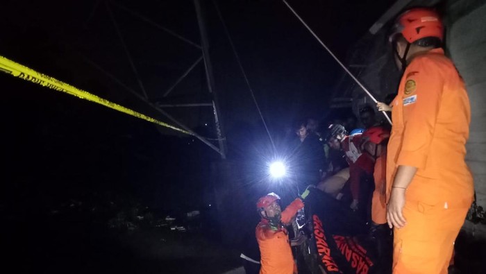 Petugas saat mengevakuasi korban yang gantung diri di tiang SUTET