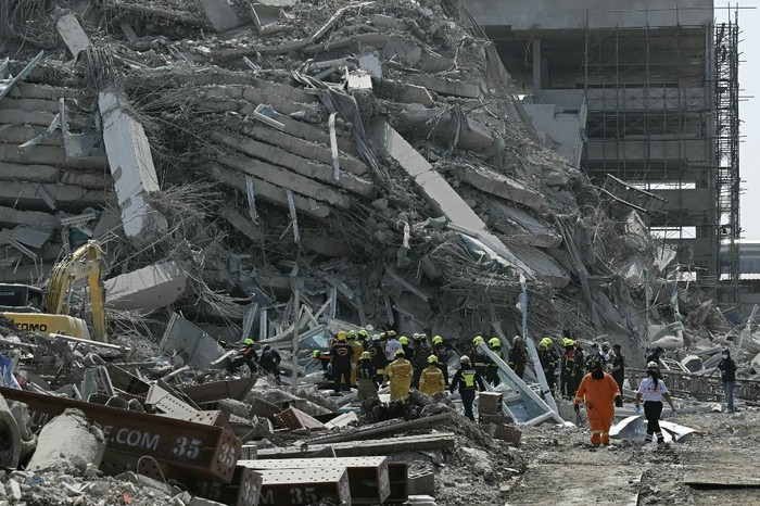 Rescue teams are seen at a construction site where a building collapsed in Bangkok on March 28, 2025, after an earthquake. A powerful earthquake rocked central Myanmar on March 28, buckling roads in capital Naypyidaw, damaging buildings and forcing people to flee into the streets in neighbouring Thailand. (Photo by Lillian SUWANRUMPHA / AFP)
