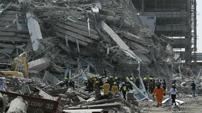 Rescue teams are seen at a construction site where a building collapsed in Bangkok on March 28, 2025, after an earthquake. A powerful earthquake rocked central Myanmar on March 28, buckling roads in capital Naypyidaw, damaging buildings and forcing people to flee into the streets in neighbouring Thailand. (Photo by Lillian SUWANRUMPHA / AFP)