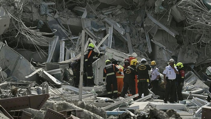 Rescue teams are seen at a construction site where a building collapsed in Bangkok on March 28, 2025, after an earthquake. A powerful earthquake rocked central Myanmar on March 28, buckling roads in capital Naypyidaw, damaging buildings and forcing people to flee into the streets in neighbouring Thailand. (Photo by Lillian SUWANRUMPHA / AFP)
