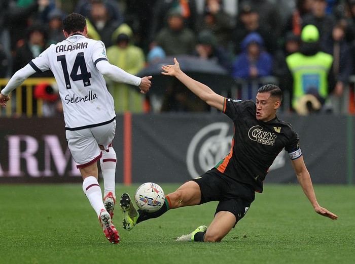 VENICE, ITALY - MARCH 29: Jay Idzes of Venezia tackles Davide Calabria of Bologna during the Serie A match between Venezia and Bologna at Stadio Pier Luigi Penzo on March 29, 2025 in Venice, Italy. (Photo by Timothy Rogers/Getty Images)