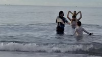 Kampung halaman Rey Mbayang dekat dengan beberapa destinasi pantai. Dinda Hauw santai bermain di pantai bersama suami dan dua anaknya. Foto: dok. Instagram Dinda Hauw