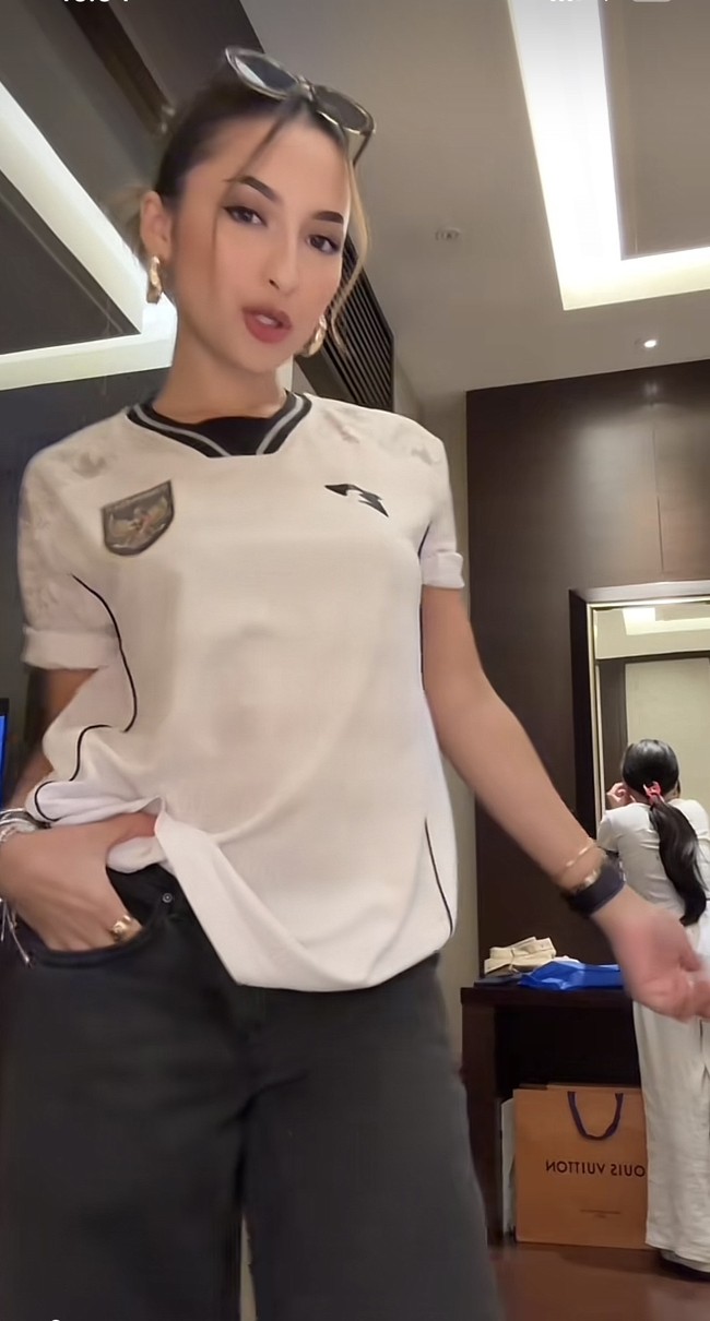 Ia memadukan jersey dengan celana jeans hitam, hop earrings emas, dan sunglasses. Foto: TikTok Jennifer Coppen